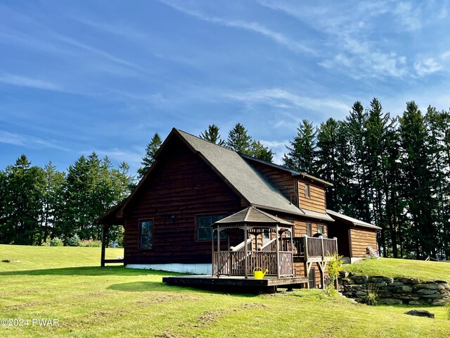 rear view of house with a yard and a deck