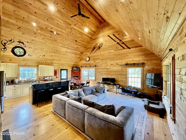 living room featuring light hardwood / wood-style flooring, high vaulted ceiling, plenty of natural light, and wood ceiling