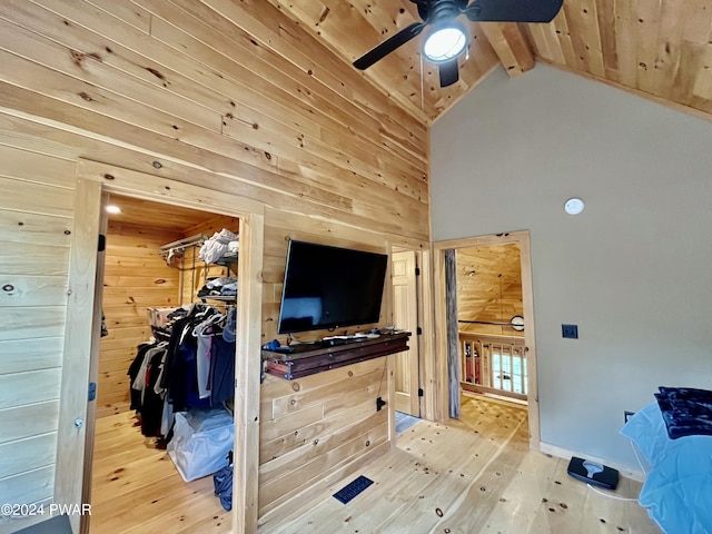 bedroom with wood ceiling, ceiling fan, vaulted ceiling with beams, a closet, and wood walls