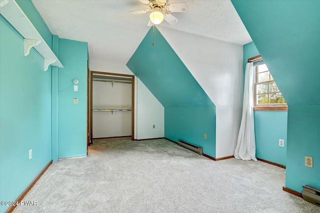 bonus room featuring ceiling fan, baseboard heating, light colored carpet, a textured ceiling, and lofted ceiling