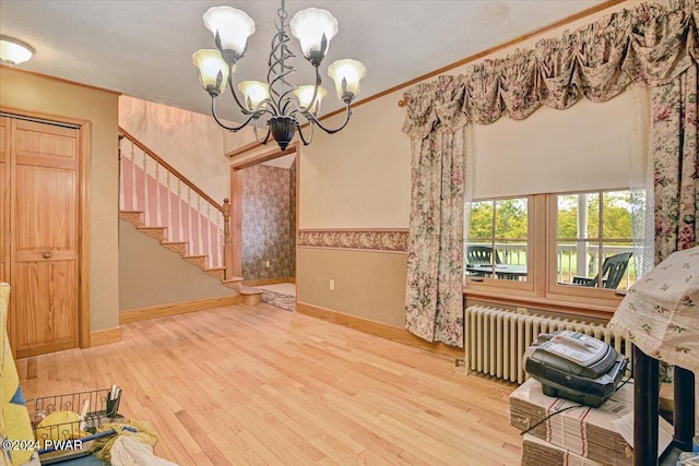 interior space with a chandelier, radiator heating unit, crown molding, and wood-type flooring