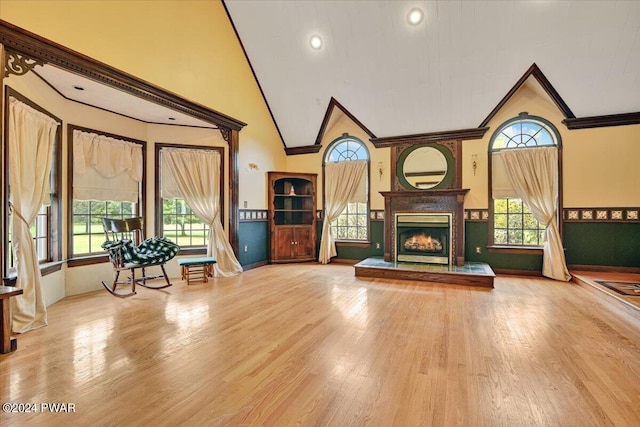 living room with high vaulted ceiling, a wealth of natural light, and light hardwood / wood-style flooring