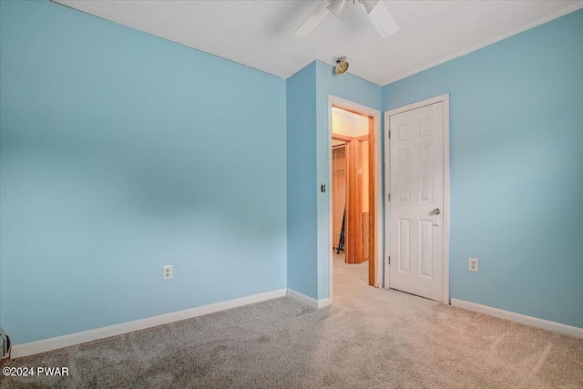 carpeted empty room featuring ceiling fan