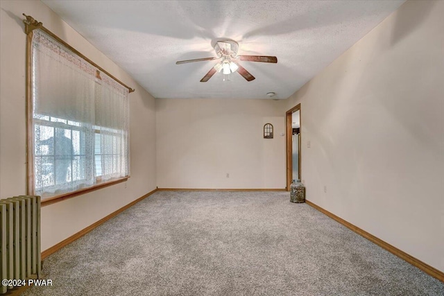 empty room with radiator, ceiling fan, carpet, and a textured ceiling