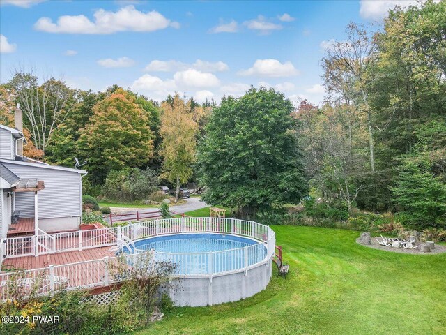 view of pool with a yard and a deck