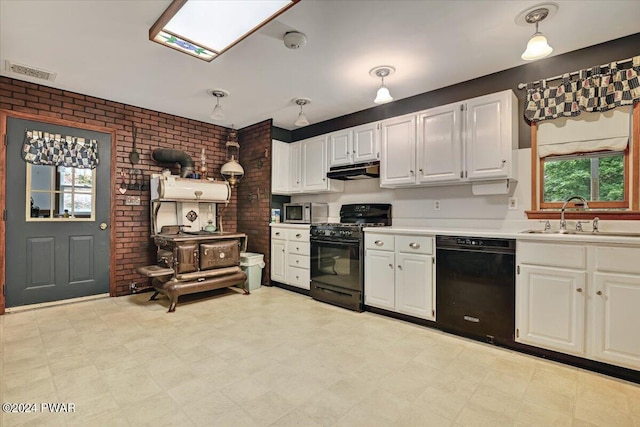 kitchen featuring brick wall, sink, black appliances, decorative light fixtures, and white cabinetry