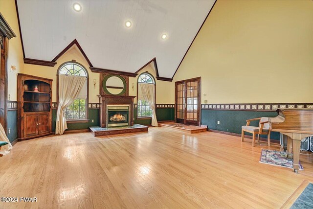 unfurnished living room featuring crown molding, high vaulted ceiling, and wood-type flooring