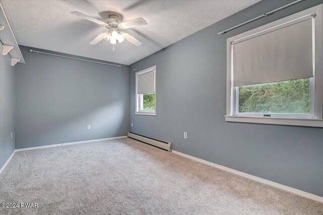 unfurnished room with a textured ceiling, ceiling fan, baseboard heating, and carpet