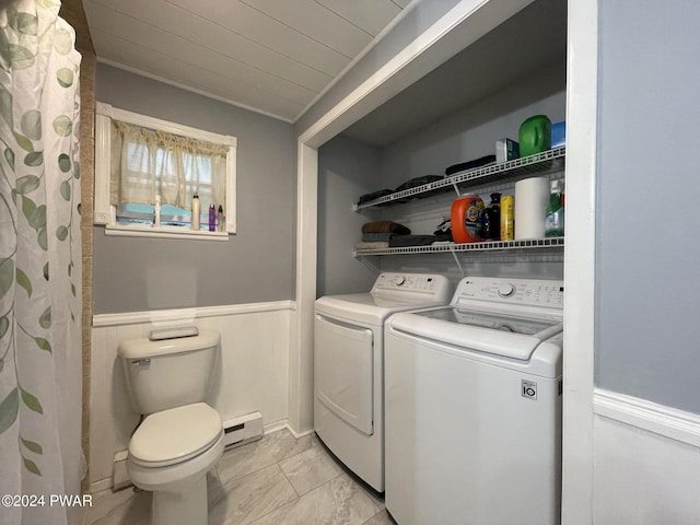 clothes washing area featuring washing machine and dryer and a baseboard heating unit