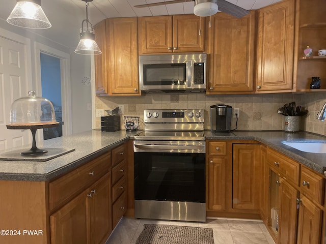 kitchen with sink, hanging light fixtures, stainless steel appliances, backsplash, and kitchen peninsula