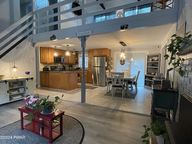 dining space with a towering ceiling and light hardwood / wood-style flooring