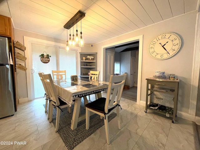 dining space with a chandelier and wood ceiling