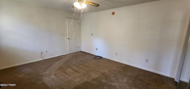 spare room with ceiling fan and dark carpet