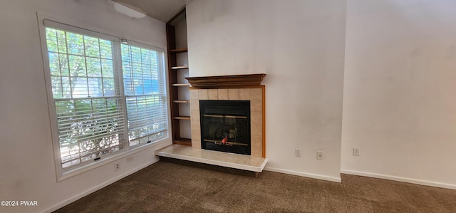 unfurnished living room featuring carpet flooring, built in shelves, and a fireplace