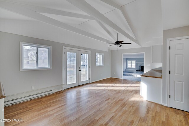 unfurnished living room featuring lofted ceiling with beams, plenty of natural light, french doors, and a baseboard radiator