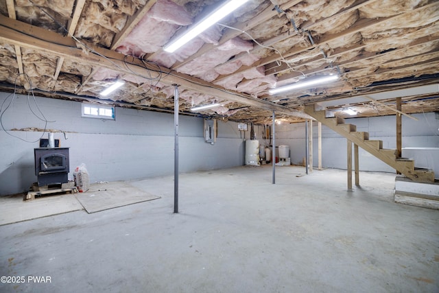 basement featuring a wood stove and water heater