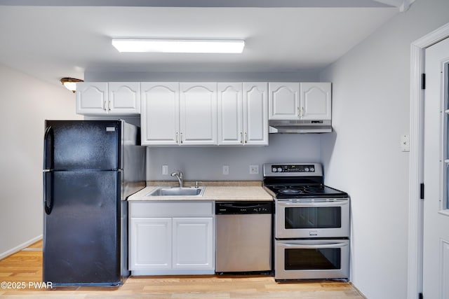 kitchen with appliances with stainless steel finishes, light hardwood / wood-style flooring, white cabinetry, and sink