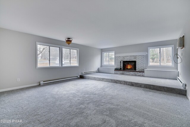 unfurnished living room featuring baseboard heating, carpet flooring, and a fireplace