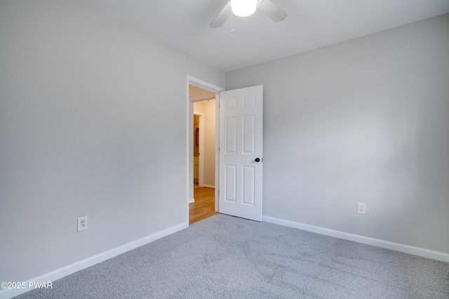 carpeted spare room with ceiling fan