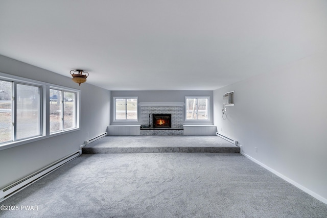 unfurnished living room with baseboard heating, light carpet, a fireplace, and a wall unit AC