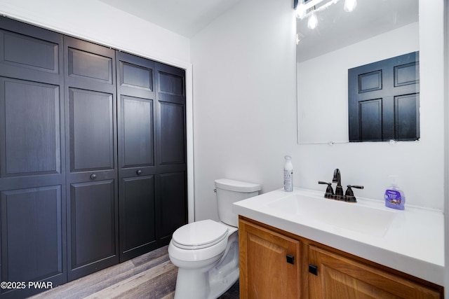 bathroom featuring vanity, hardwood / wood-style floors, and toilet