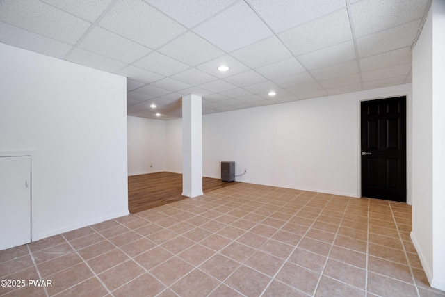 basement with light tile patterned flooring and a drop ceiling