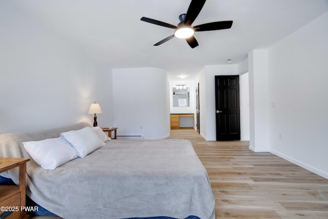 bedroom with ceiling fan, ensuite bathroom, a baseboard radiator, and light wood-type flooring