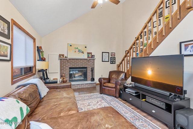 living room with ceiling fan, a fireplace, lofted ceiling, and hardwood / wood-style flooring