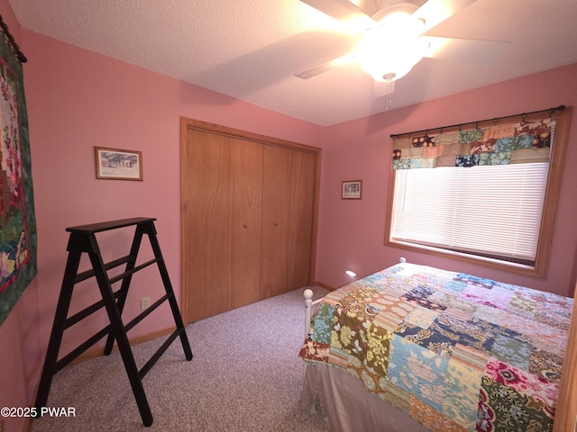bedroom with carpet floors, a ceiling fan, a closet, and a textured ceiling