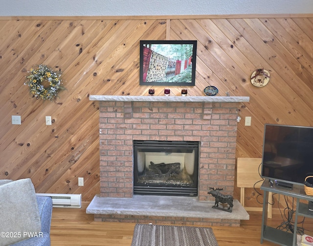 room details featuring wooden walls, visible vents, wood finished floors, and a brick fireplace