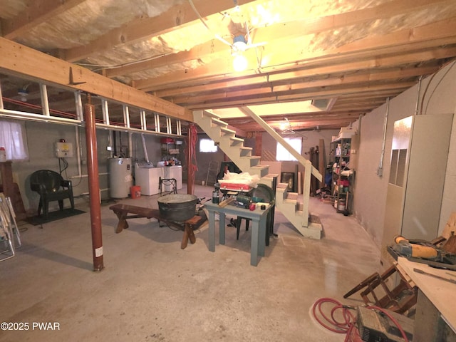 unfinished below grade area with electric water heater, stairway, and washing machine and dryer