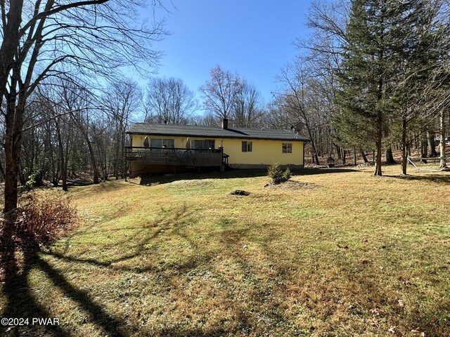 exterior space with a deck and a lawn