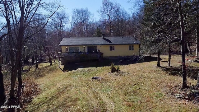 back of house featuring a lawn and a deck