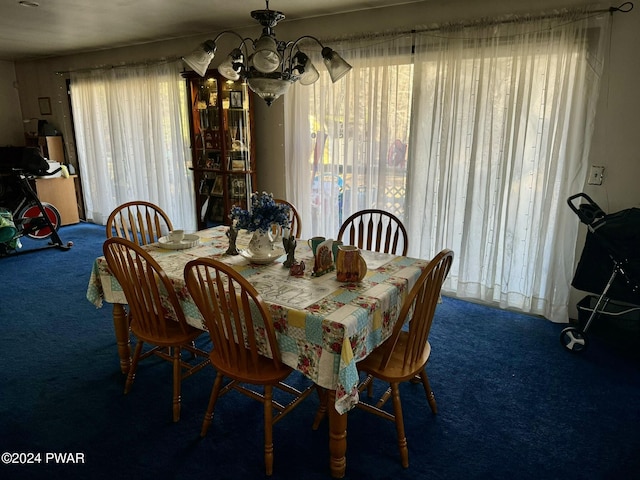 dining room with dark colored carpet and a chandelier