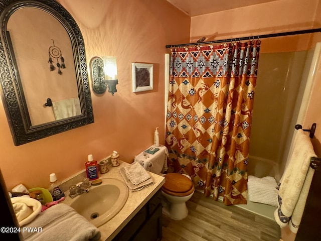 full bathroom featuring wood-type flooring, vanity, toilet, and shower / tub combo with curtain