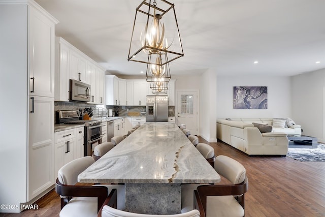 dining space featuring dark wood-type flooring and a notable chandelier