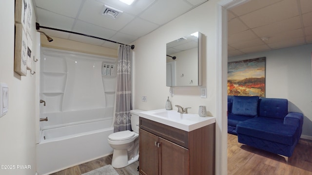 full bathroom with toilet, vanity, shower / bath combo with shower curtain, hardwood / wood-style flooring, and a drop ceiling