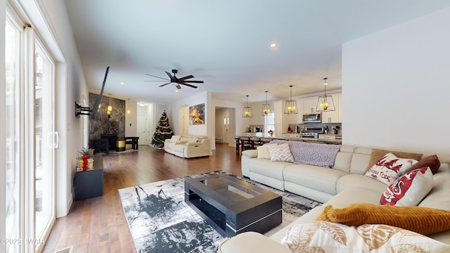 living room with dark wood-type flooring and ceiling fan