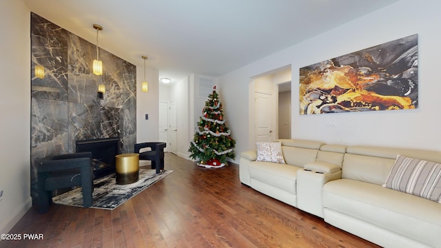 living room featuring dark wood-type flooring and a high end fireplace