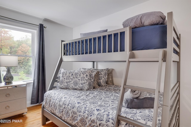 bedroom with multiple windows and hardwood / wood-style floors