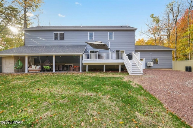 rear view of property featuring a wooden deck and a lawn