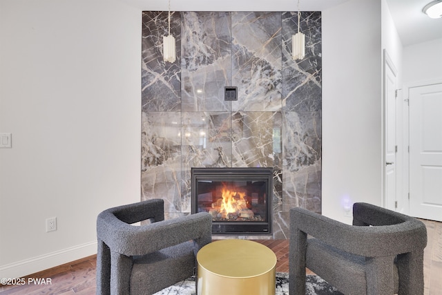 living area featuring hardwood / wood-style flooring and a tiled fireplace