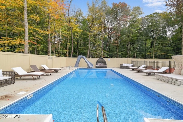 view of swimming pool with a patio and a water slide