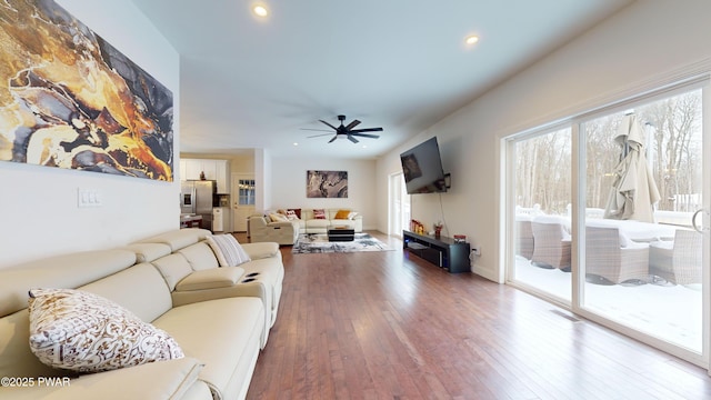 living room with dark wood-type flooring and ceiling fan