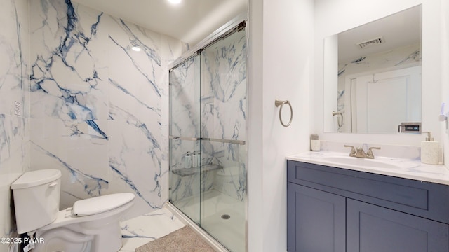 bathroom featuring toilet, vanity, and a shower with shower door