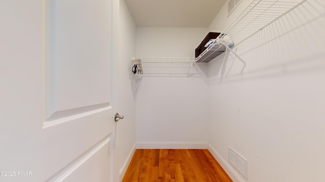 walk in closet with hardwood / wood-style flooring