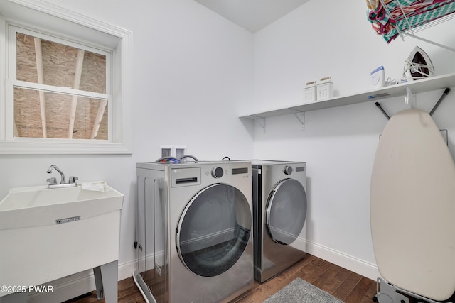 laundry area featuring separate washer and dryer, sink, and dark hardwood / wood-style floors