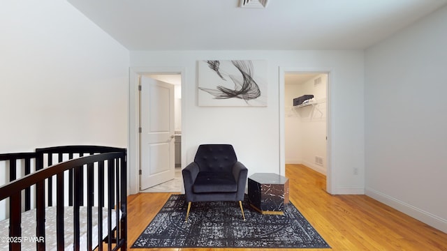 bedroom featuring hardwood / wood-style flooring and a walk in closet