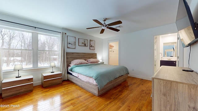 bedroom featuring ceiling fan, connected bathroom, and light hardwood / wood-style floors