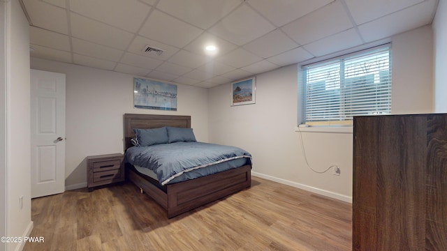 bedroom with light hardwood / wood-style flooring and a paneled ceiling